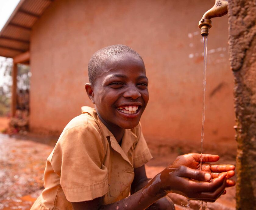 smiling-black-african-schoolboy-drinking-from-a-ta-2023-11-27-04-55-06-utc